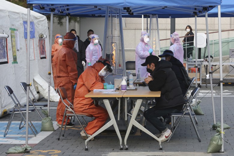 Медицина қызметкерлері Сеулдегі жылжымалы орталықта коронавируске тексеруде